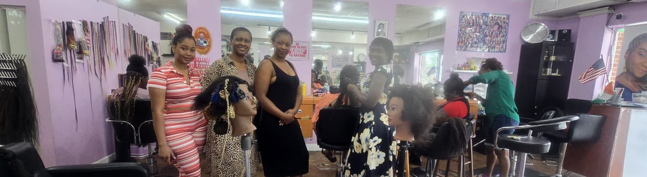 The Akwaba stylists gathered in the salon beside braiding chairs and hair displays
